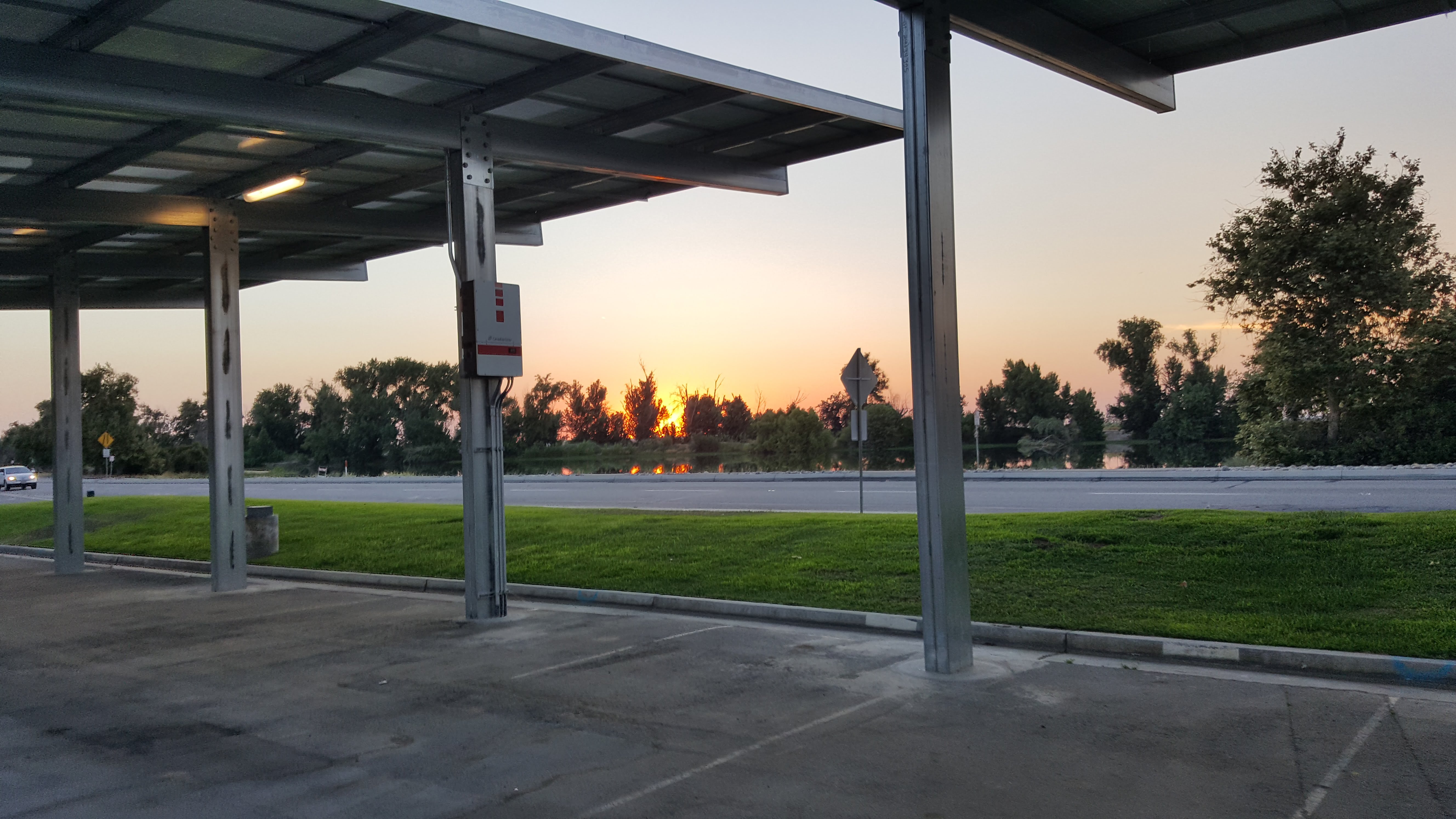 Solar carport structure at sunset providing covered parking and clean energy