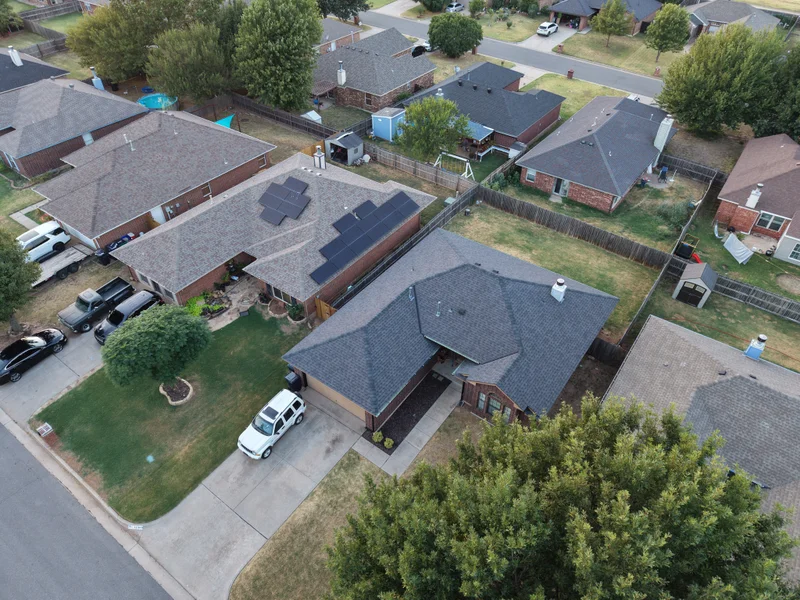 The Yukon home before roof replacement, with solar panels on two areas of the existing roof